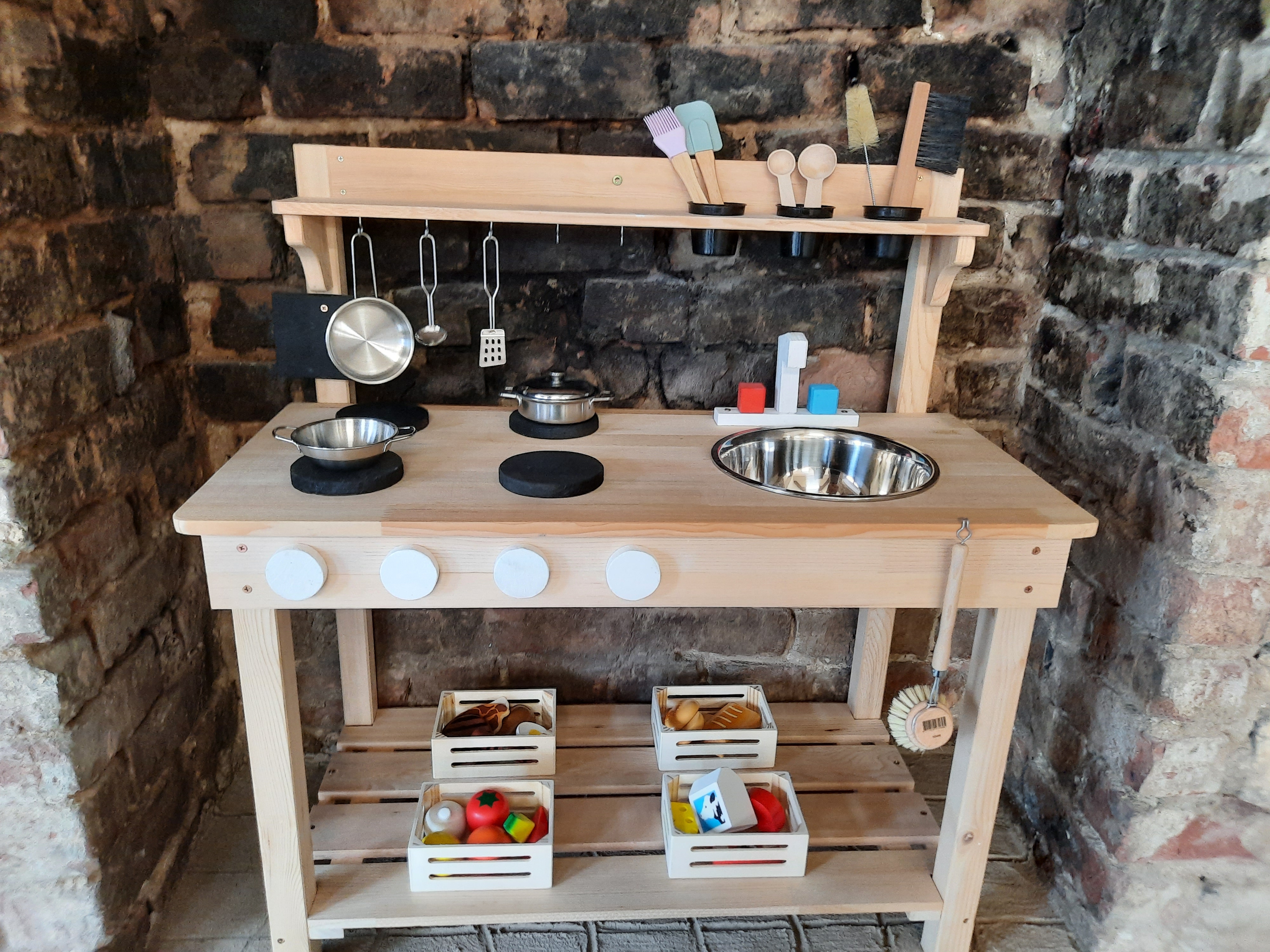 Wooden kitchen set in stone fireplace in preschool room